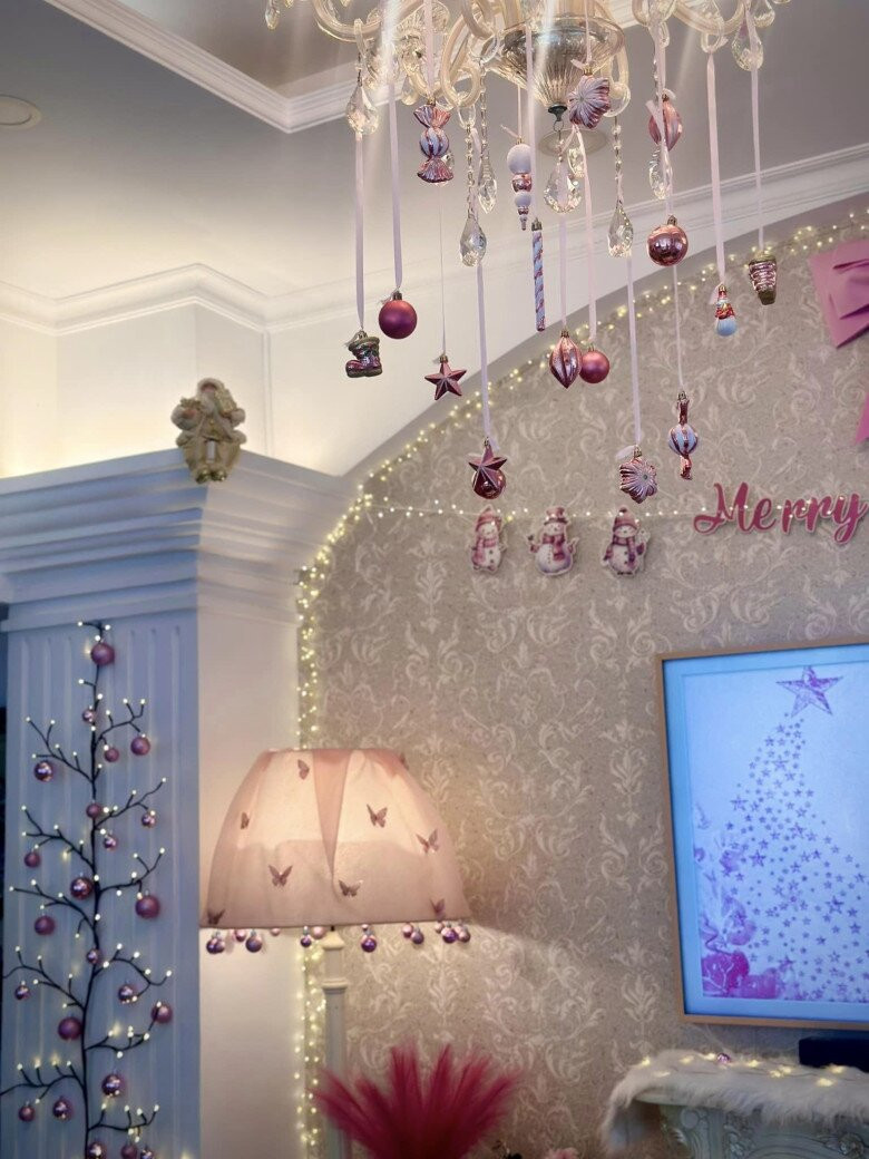 Phòng khách lộng lẫy với đèn chùm pha lê và cây thông màu hồng. Ảnh: FBNV