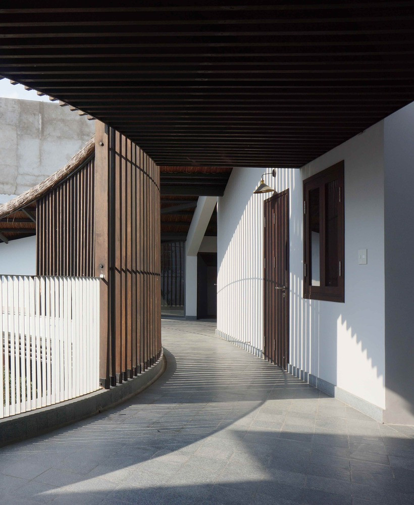 Hành lang cong mềm mại ôm lấy khoảng sân trong xanh mát. Ảnh: Sơn Vũ