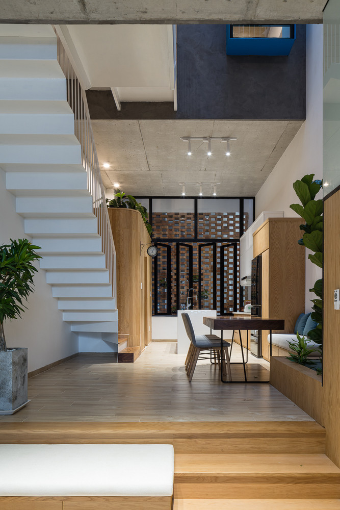 Khoảng không gian sàn lớn giữa nhà giúp không gian bên trong sáng sủa và thoáng đãng (nắng được điều chỉnh bằng hệ thống thanh xoay và gió qua các khe gạch), đồng thời tăng sự tương tác và gắn kết giữa các thành viên trong gia đình. Ảnh: Quang Trần