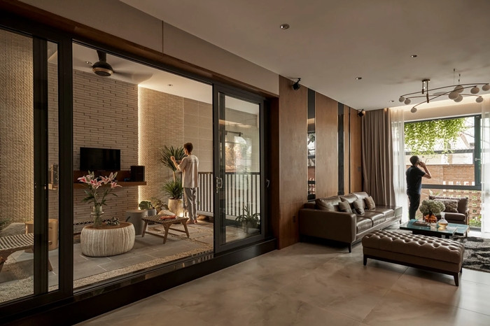 Ở bên trong, kiến trúc sư chọn màu nâu và be làm tông màu chủ đạo kết hợp chất liệu gỗ, kính và sàn bê tông. Ảnh: Phú Đào Studio