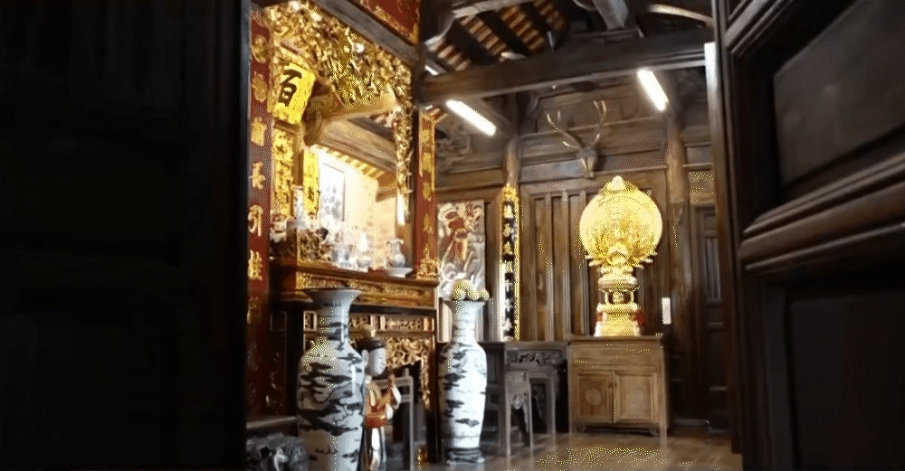 Trong căn nhà cổ 100m2 là không gian thờ tự của gia đình, được bài trí với bộ bàn ghế gỗ, sập tủ chè, câu đối... Ảnh chụp màn hình