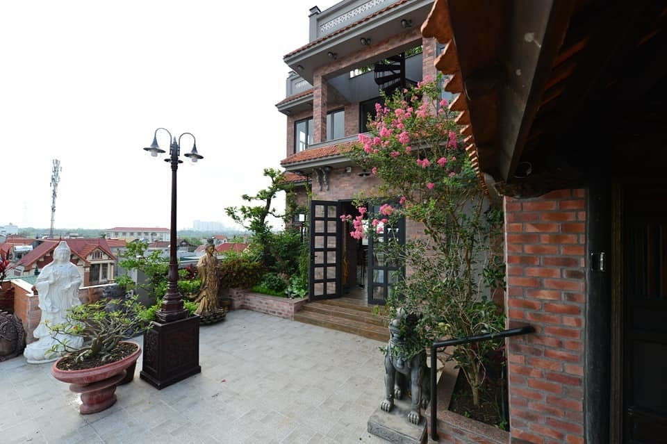 Sát cạnh gian nhà cổ là không gian hiện đại được gia chủ để tường gạch, ngói đỏ hòa quyện cùng nét truyền thống xưa cũ của căn nhà trăm tuổi. Ảnh chụp màn hình