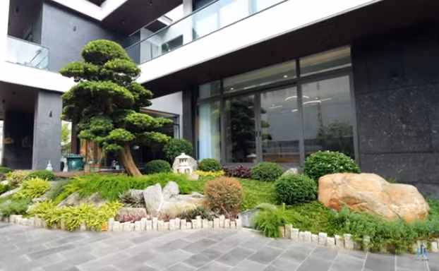 Bên ngoài căn biệt thự có sân vườn, cây cối, gần gũi thiên nhiên mang đến cảm giác như ở trong một khu nghỉ dưỡng. Ảnh chụp màn hình NhaF