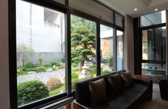 Cửa kính lớn vừa giúp lấy ánh sáng vừa có thể phóng tầm mắt ngắm khu vườn bên ngoài. Ảnh chụp màn hình NhaF