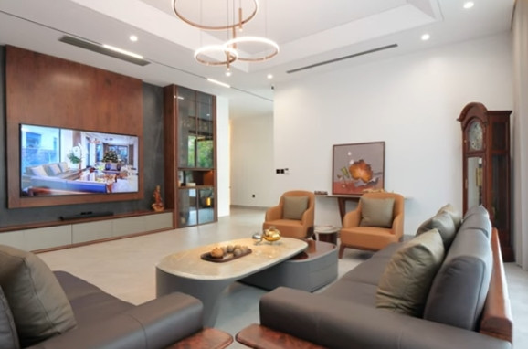 Tầng 1 của ngôi nhà có diện tích rộng, lên tới 280m2. Phòng khách thiết kế tối giản nhưng không kém phần tinh tế. Ảnh chụp màn hình NhaF