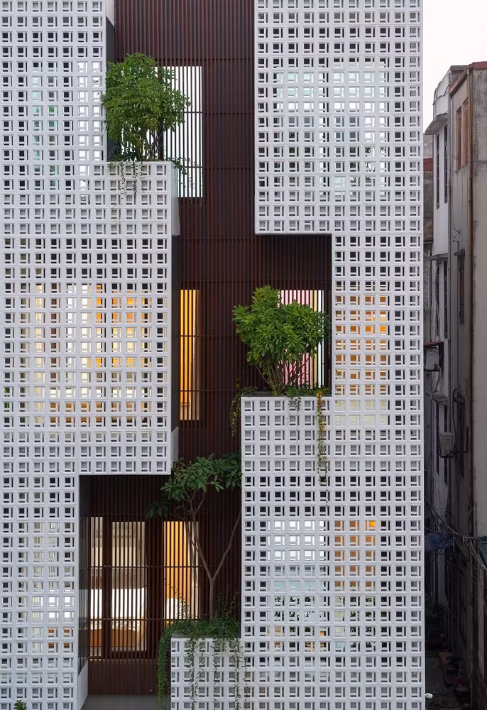 Công trình mang đến một làn gió mới, một dòng nước mát lành, thoát khỏi sự chật chội, bí bách. Ý tưởng này được thể hiện khéo léo bởi mặt tiền gạch hoa gió kết hợp nhôm hộp giả gỗ. Ảnh: Triệu Chiến