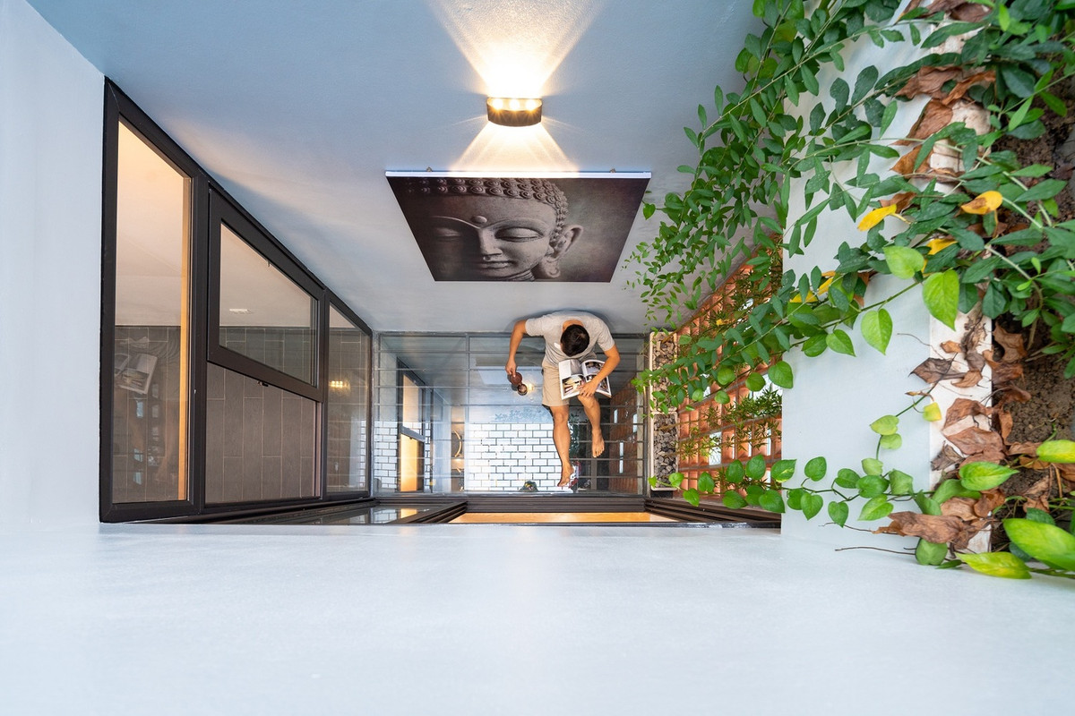 Để mọi không gian đều tiếp xúc với ánh sáng tự nhiên và thông gió, kiến trúc sư mở giếng trời theo trục đứng để tạo không gian xanh cho các phòng chức năng xung quanh. Ảnh: Triệu Chiến