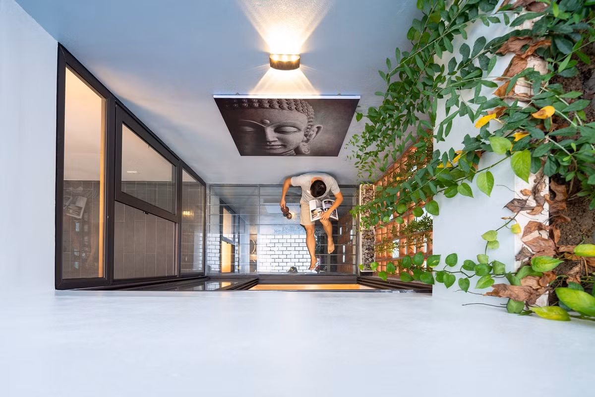 Để mọi không gian đều tiếp xúc với ánh sáng tự nhiên và thông gió, kiến trúc sư mở giếng trời theo trục đứng để tạo không gian xanh cho các phòng chức năng xung quanh. Ảnh: Triệu Chiến