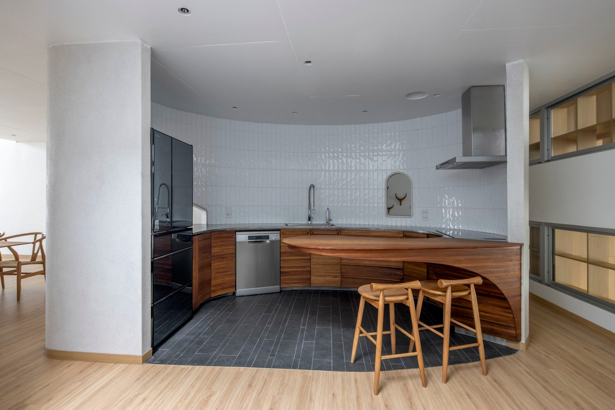 Nhà bếp thiết kế ấn tượng với đường cong mềm mại. Ảnh: Chimnon studio