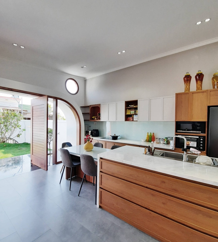 Hệ thống cửa gỗ - kính cao hơn 2m, rộng hơn 5m giúp không gian ngập ánh sáng và gió. Ảnh: BL Architects