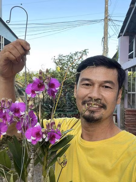 Tiết Cương thích thú khoe hoa lan tím. Ảnh: FBNV