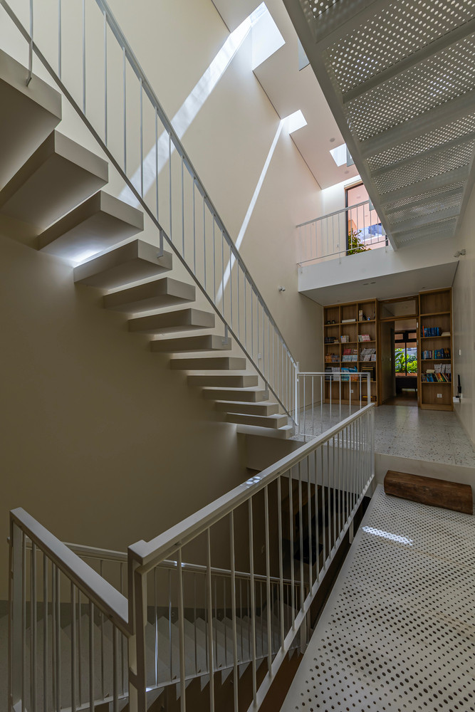 Kiến trúc sư đề xuất thiết kế nhà lệch tầng và cắt giảm diện tích sàn ở các tầng trên nhằm tăng kết nối theo chiều dọc đồng thời tạo lối đi cho ánh sáng ban ngày chiếu sâu hơn vào nhà. Ảnh: Paul Phan