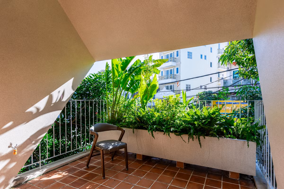 Cây xanh trồng ở ban công tầng 2 tạo thành lớp đệm ngăn bức xạ nhiệt từ phía Tây và tăng yếu tố riêng tư cho gia chủ. Ảnh: Paul Phan