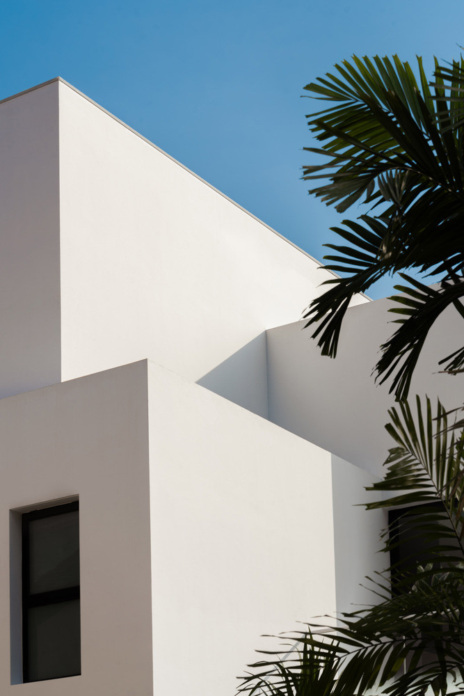 Bên ngoài căn nhà mang gam màu trắng chủ đạo. Mặt tiền không bố trí cửa sổ, lối vào nằm ẩn sau bức tường. Ảnh: Studio Stacked