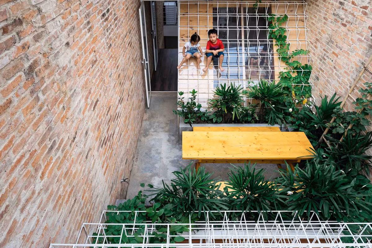 Đó cũng là cách kiến trúc sư đã thực hiện công trình này, với tinh thần của một người thợ thủ công, cẩn thận và tỉ mỉ, kết nối từng bộ phận của căn nhà với nhau, giữa cũ và mới, riêng và chung, gỗ, gạch, bê tông, kim loại và cây cối. Ảnh: Quang Đàm