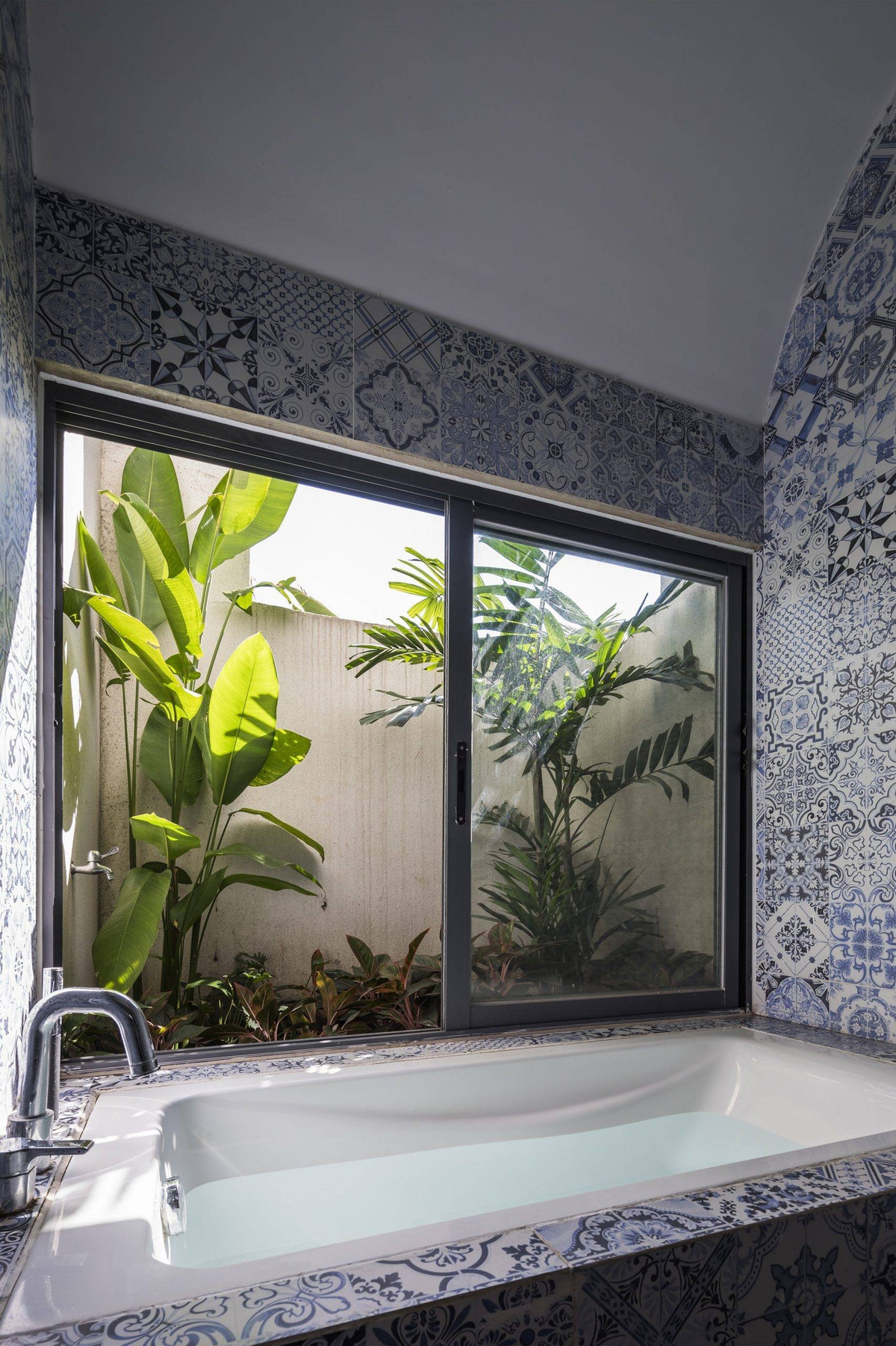 Cây xanh và gạch họa tiết ốp tường làm nổi bật không gian thư giãn và thuần Việt. Ảnh: 6717 studio