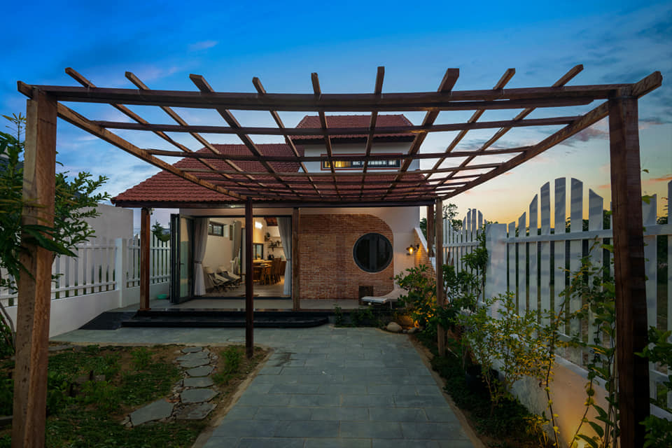 Khối nhà chính được thiết kế lùi sâu, chừa lại khoảng sân trước để đón nắng gió và làm không gian thư giãn cho gia đình. Ảnh: Greenconcept