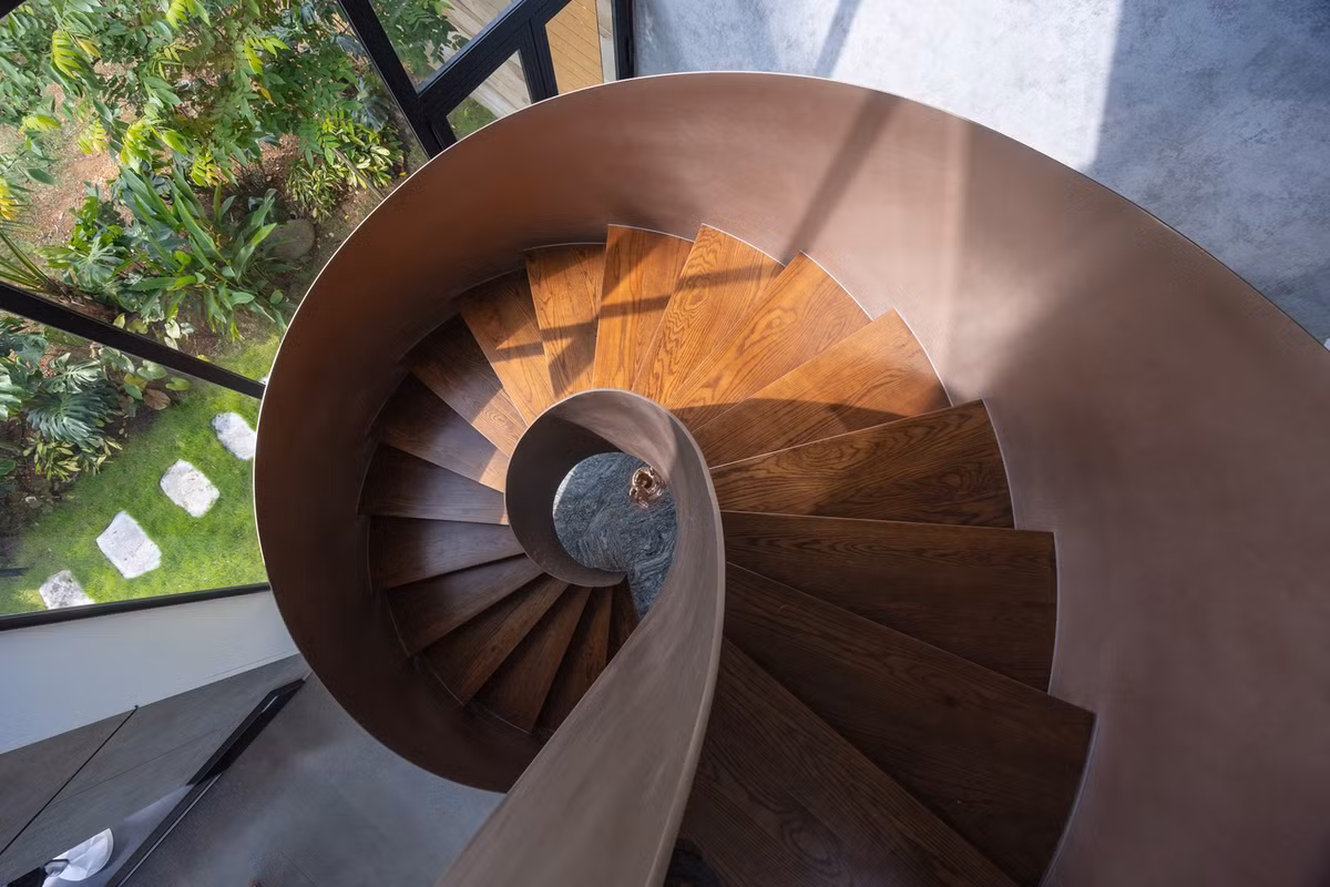 Cầu thang tạo sự kết nối liền mạch giữa các tầng và mái nhà, vừa là lối đi vừa tạo nhịp điệu kiến trúc của các khối xếp chồng. Ảnh: Trieu Chien