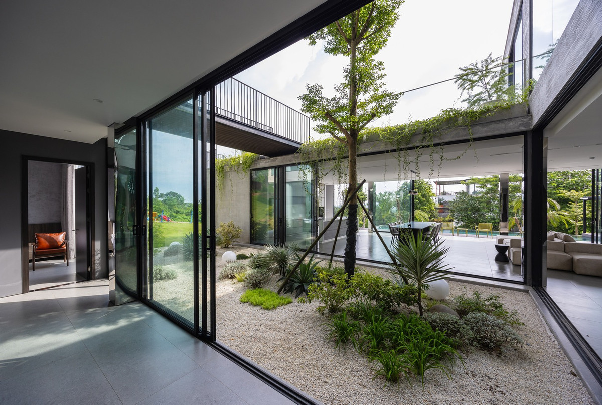 Giữa các khối, sân vườn và lối đi ngoài trời được bố trí một cách chiến lược, tạo ra không gian xanh liên tục kết nối tự nhiên các khu vực khác nhau của ngôi nhà. Ảnh: Trieu Chien