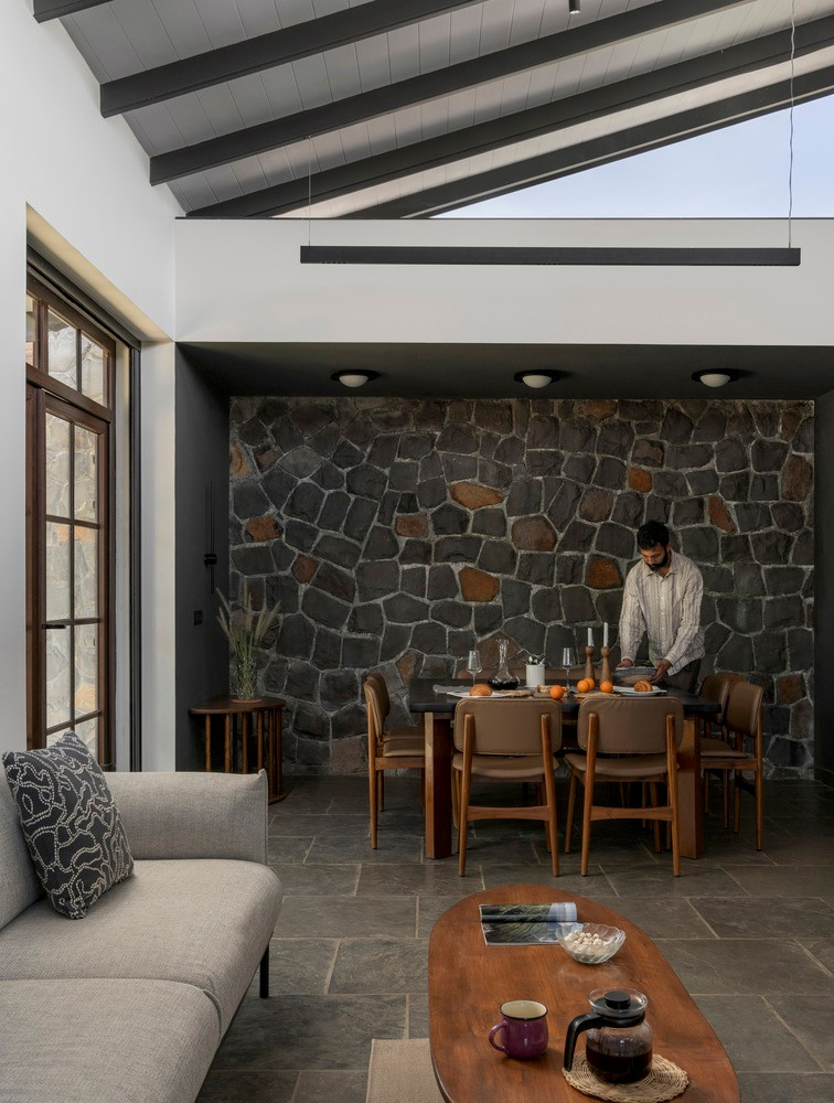 Bên cạnh đó, bức tường đá còn làm phông nền cho các khu vực chức năng như không gian ăn uống, nấu nướng và phòng tắm. Ảnh: Archdaily