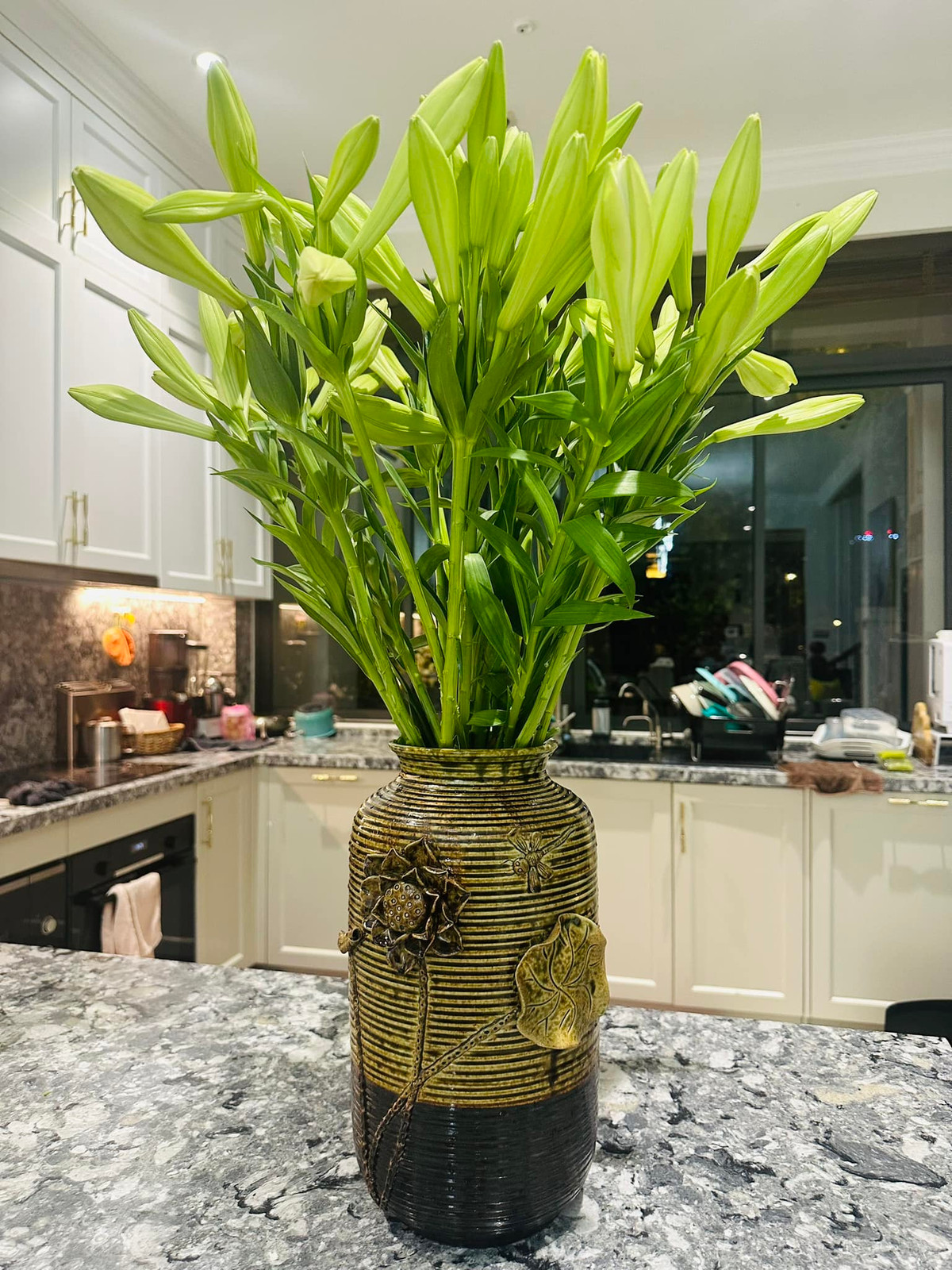 Phòng bếp cũng có tông trắng chủ đạo, được tô điểm bằng những bình hoa tươi. Ảnh: FB Nguyễn Thanh Vân