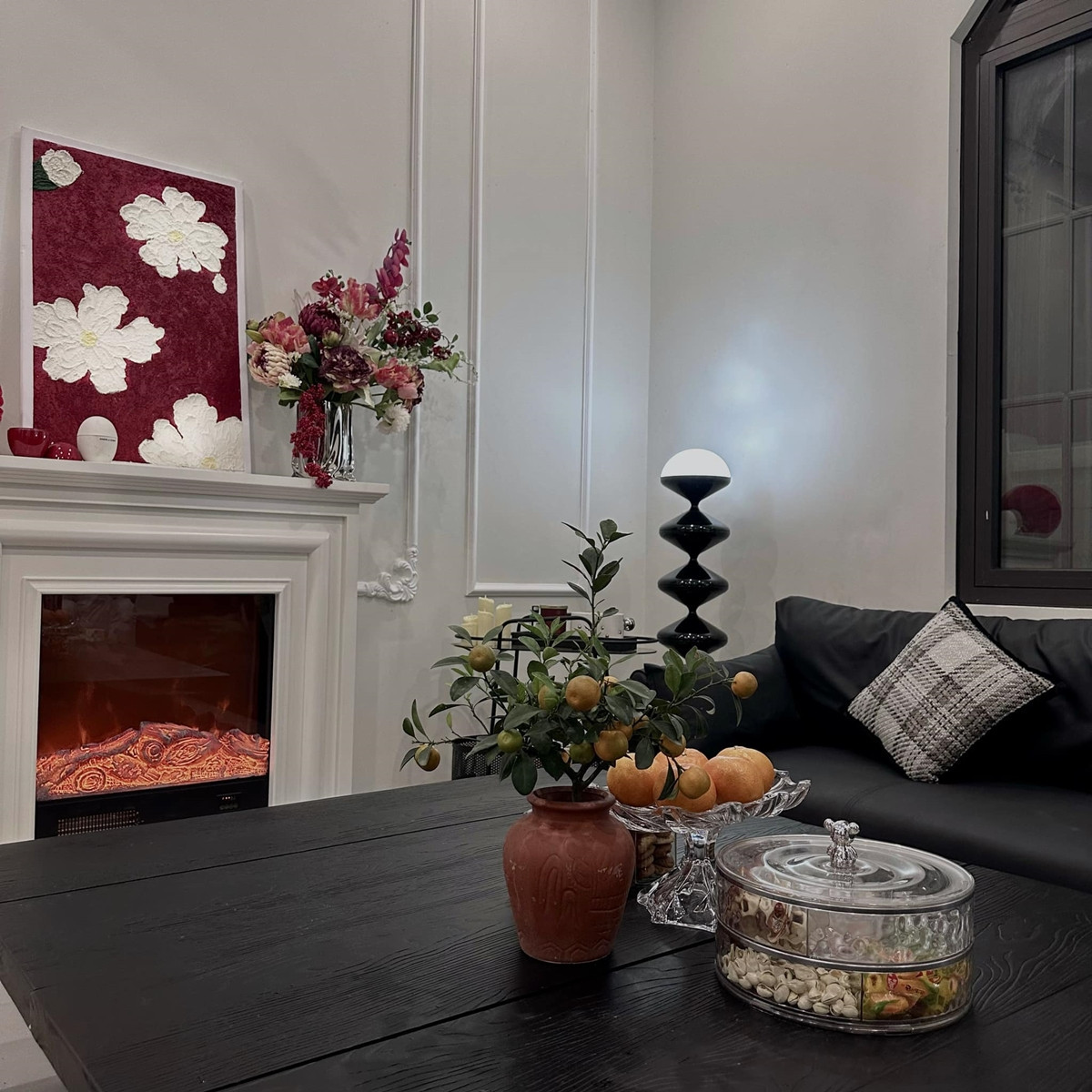 Phòng khách nổi bật với sofa màu đen và lò sưởi ấm áp. Ảnh: FBNV