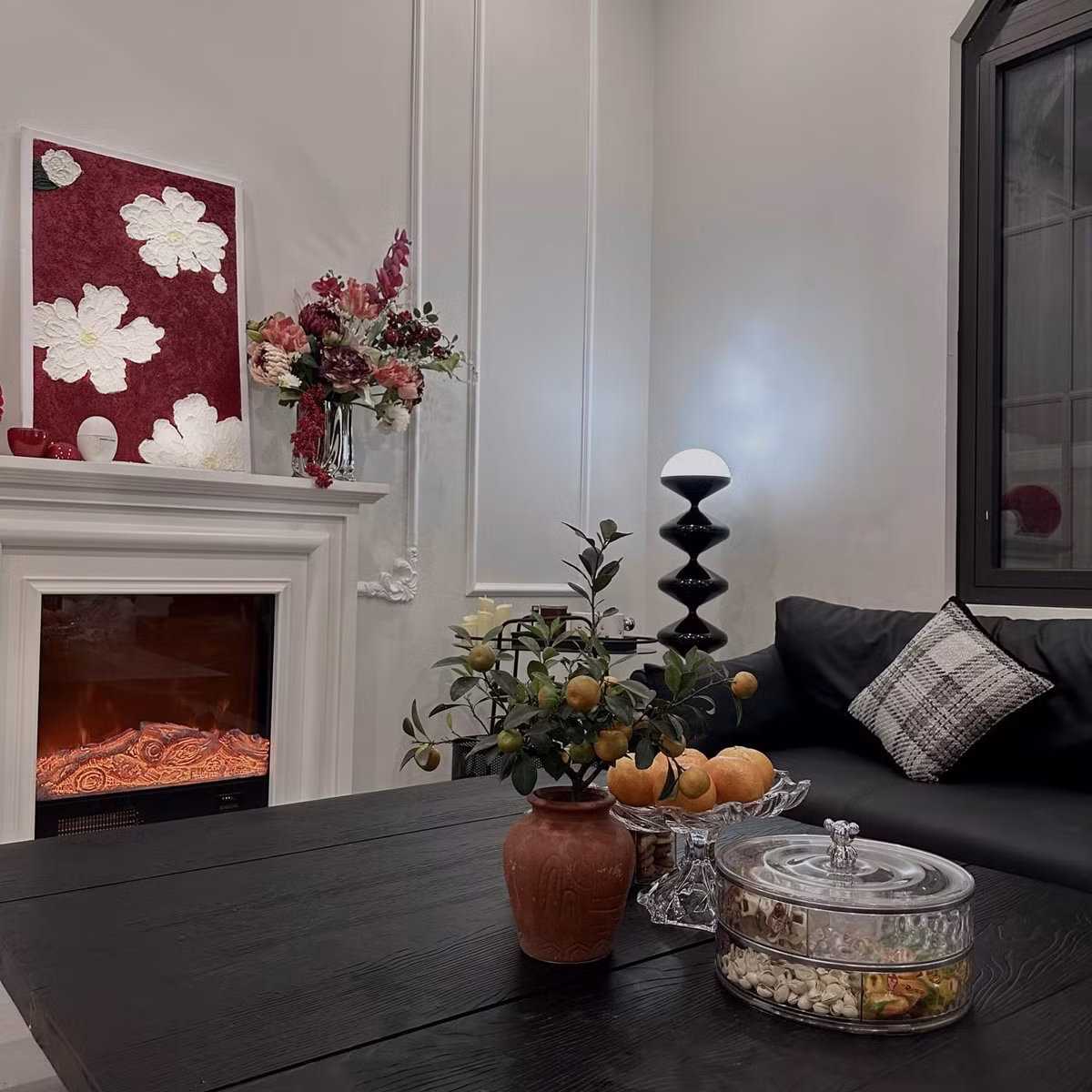 Phòng khách nổi bật với sofa màu đen và lò sưởi ấm áp. Ảnh: FBNV