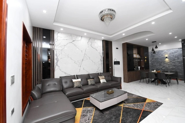 Phòng khách rộng rãi với bộ sofa màu đen nổi bật. Ảnh: FBNV