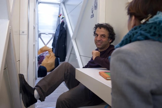 Tầng 1 là phòng khách, hẹp đến nỗi chân khi ngồi không thể duỗi ra được. Ảnh: Archdaily