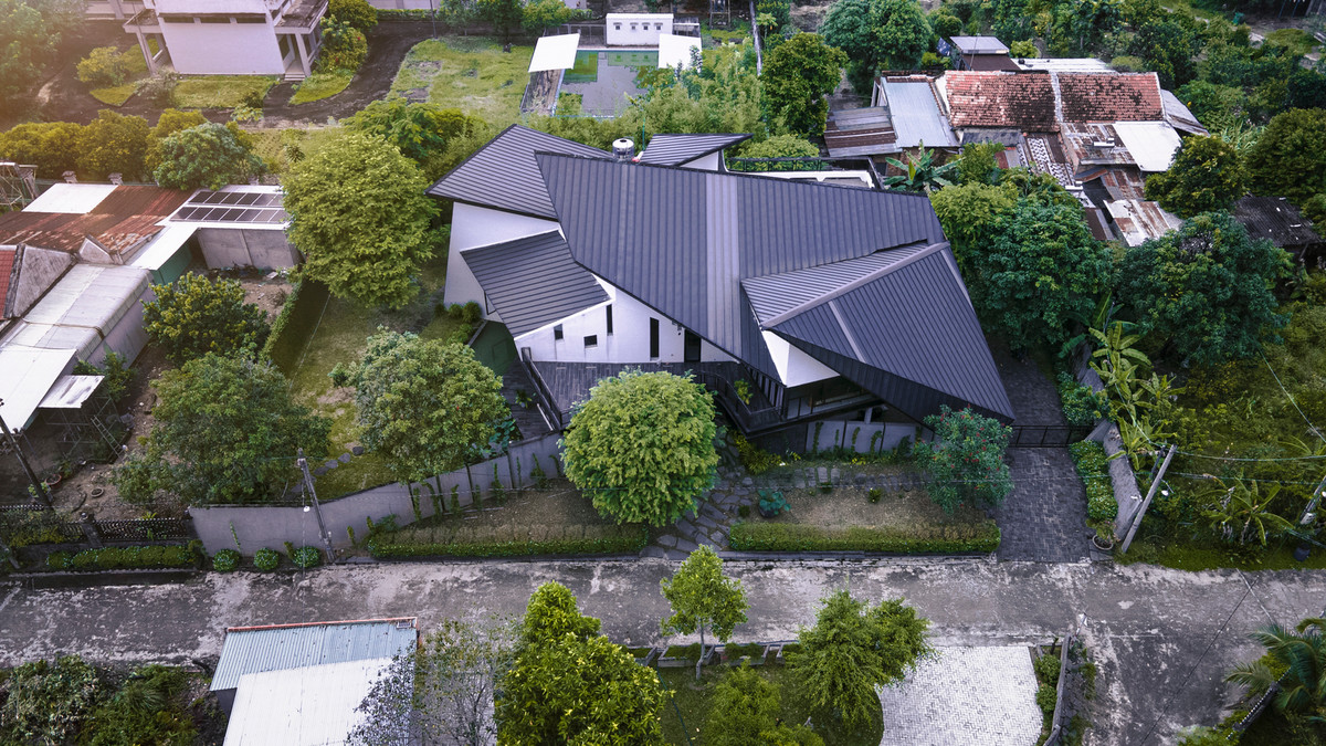 Nằm trên khu đất có thế cao hơn xung quanh, căn nhà nổi bật với phần mái tượng trưng cho những cánh diều chao lượn trên đồng cỏ bạt ngàn gió và nắng như nhắc về những tháng ngày anh chị em cùng sinh sống với nhau. Ảnh: Dung Huỳnh