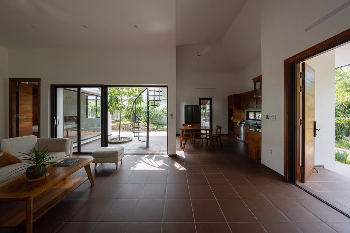 Không gian dưới mái hiên thiết kế giật cấp theo địa hình thoải dốc của khu đất, kết nối với một sân nhỏ, dẫn đến phòng khách, bếp và phòng ngủ. Ảnh: Cao Hoa