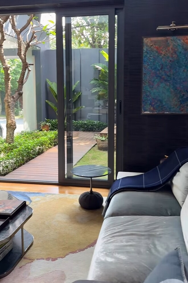 Từ phòng khách có thể nhìn thấy sân vườn xanh mát qua cửa kính lớn. Ảnh: FBNV