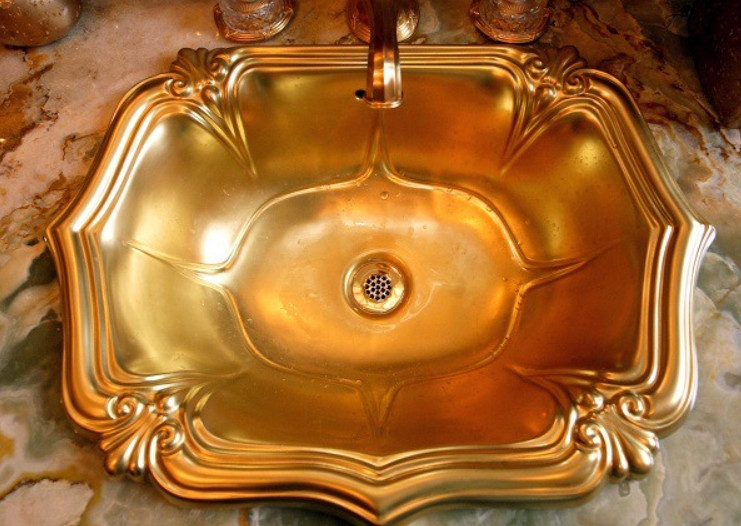 Một bồn rửa mạ vàng trên mặt bàn trang điểm bằng đá trong phòng vệ sinh nữ. Ảnh: Ajc
