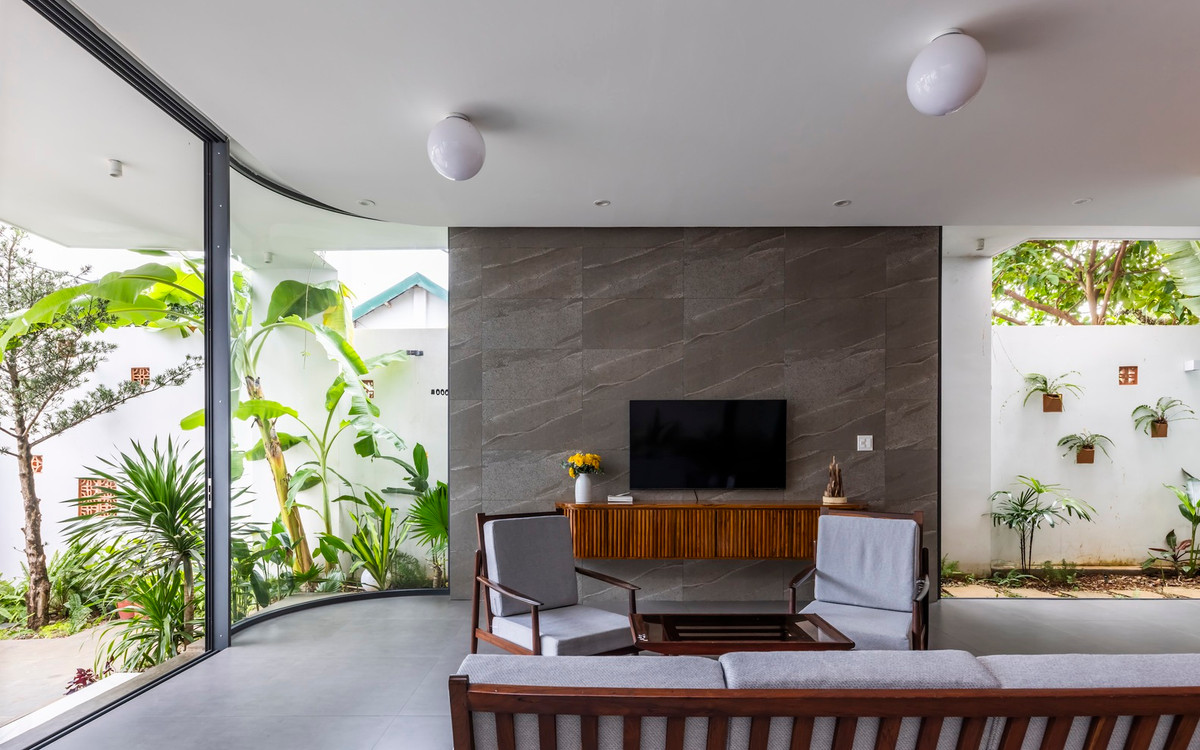 Phòng khách mang phong cách tối giản nhưng tinh tế, với gỗ là vật liệu chủ đạo, mang đến sự ấm áp và cảm giác gần gũi. Cây xanh được bố trí xung quanh không gian, kết hợp với ánh sáng tự nhiên từ cửa kính, tạo nên môi trường sống trong lành và thoáng mát. Ảnh: Hiroyuki Oki