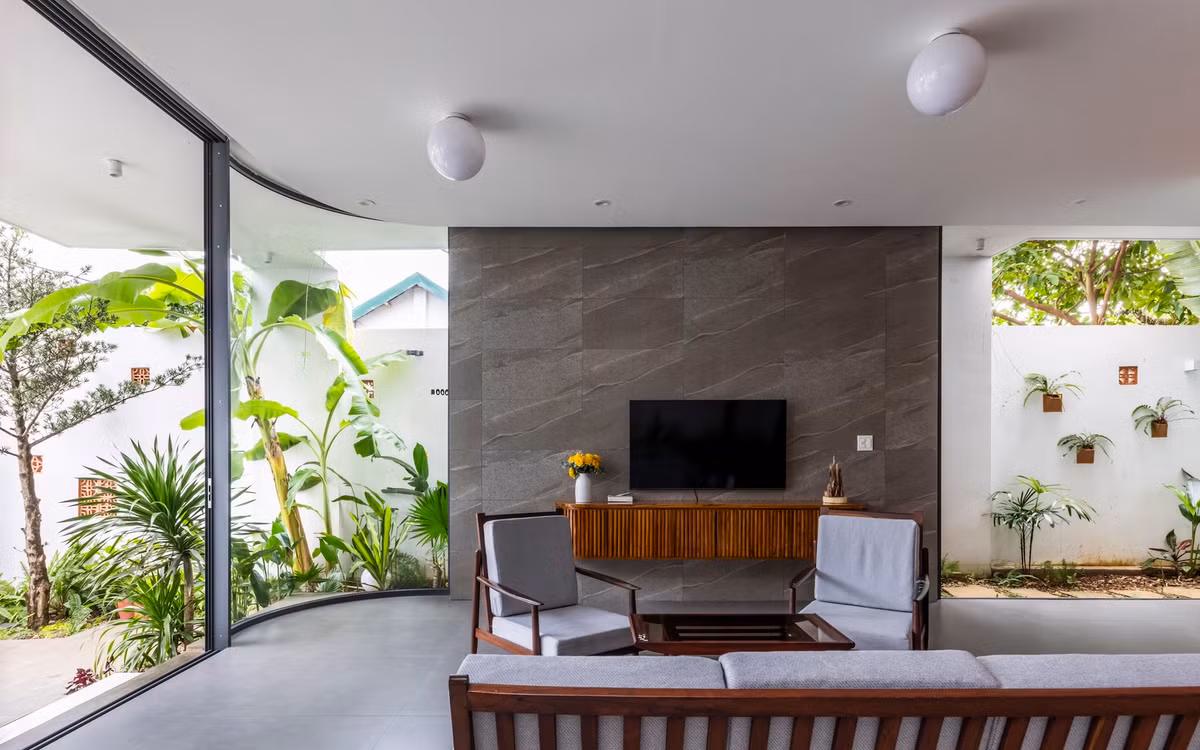 Phòng khách mang phong cách tối giản nhưng tinh tế, với gỗ là vật liệu chủ đạo, mang đến sự ấm áp và cảm giác gần gũi. Cây xanh được bố trí xung quanh không gian, kết hợp với ánh sáng tự nhiên từ cửa kính, tạo nên môi trường sống trong lành và thoáng mát. Ảnh: Hiroyuki Oki