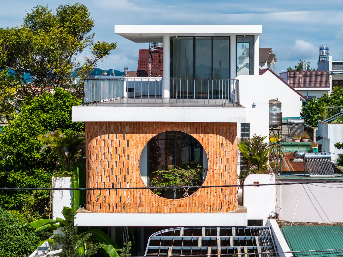 Cửa sổ tròn lớn ở tầng trên là điểm nhấn chính của mặt tiền, không chỉ đóng vai trò thẩm mỹ mà còn là sự kết nối giữa căn nhà và môi trường xung quanh, mang đến tầm nhìn thoáng đãng và ánh sáng tự nhiên. Ảnh: Hiroyuki Oki