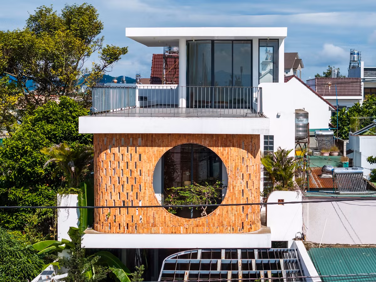 Cửa sổ tròn lớn ở tầng trên là điểm nhấn chính của mặt tiền, không chỉ đóng vai trò thẩm mỹ mà còn là sự kết nối giữa căn nhà và môi trường xung quanh, mang đến tầm nhìn thoáng đãng và ánh sáng tự nhiên. Ảnh: Hiroyuki Oki