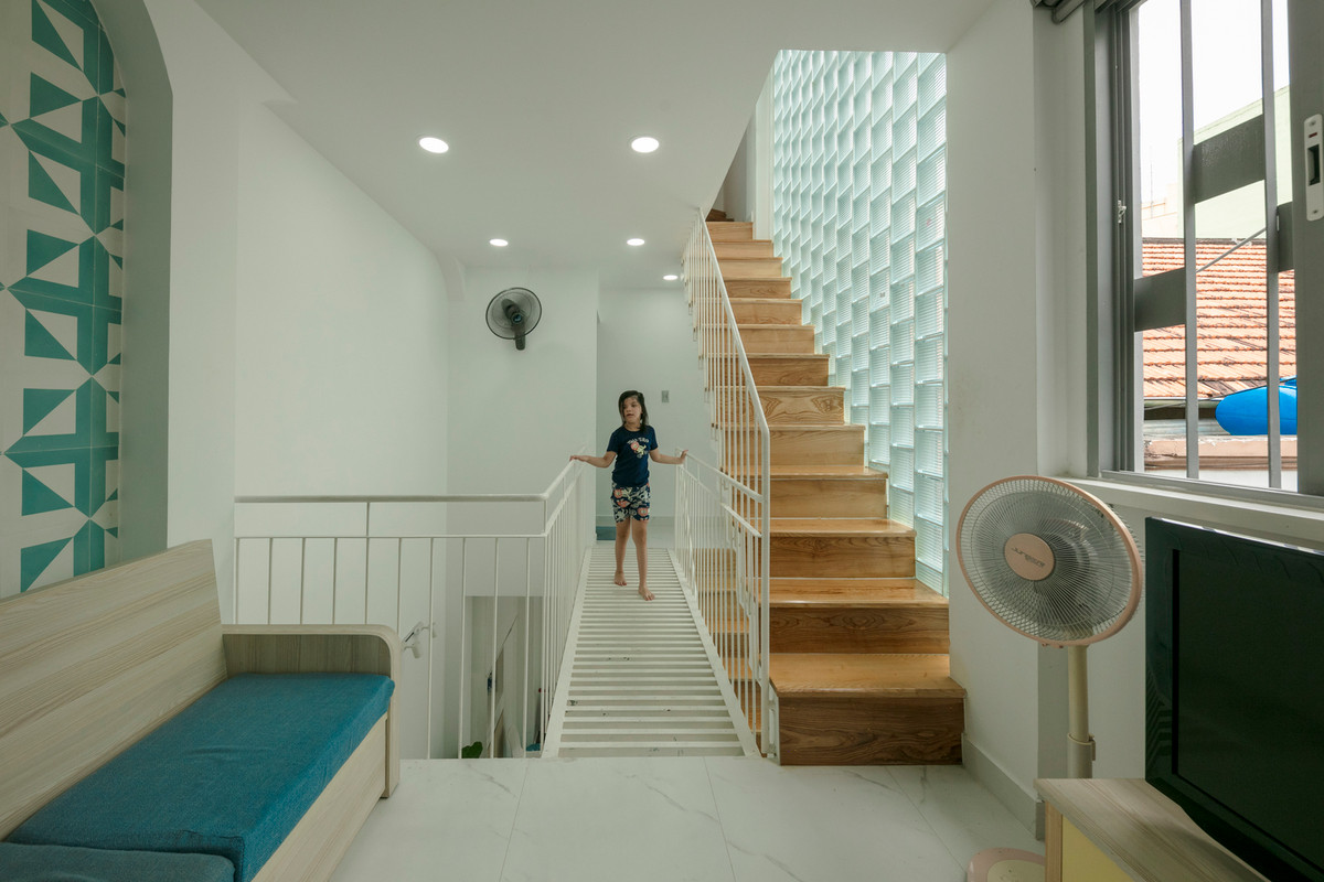 Hành lang và cầu thang được bố trí ngay với mặt tiền tạo vùng đệm, giúp giảm nhiệt và làm mát cho các phòng ngủ bên trong. Ảnh: Thiết Vũ