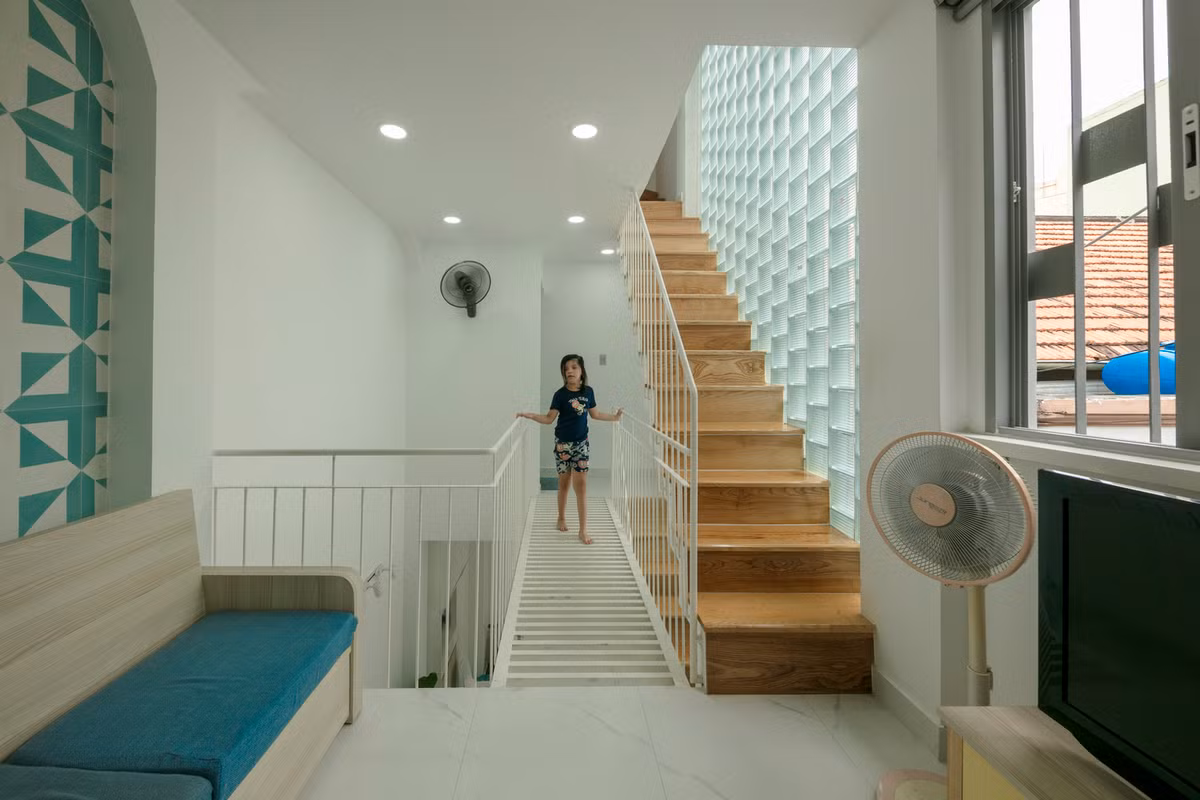 Hành lang và cầu thang được bố trí ngay với mặt tiền tạo vùng đệm, giúp giảm nhiệt và làm mát cho các phòng ngủ bên trong. Ảnh: Thiết Vũ