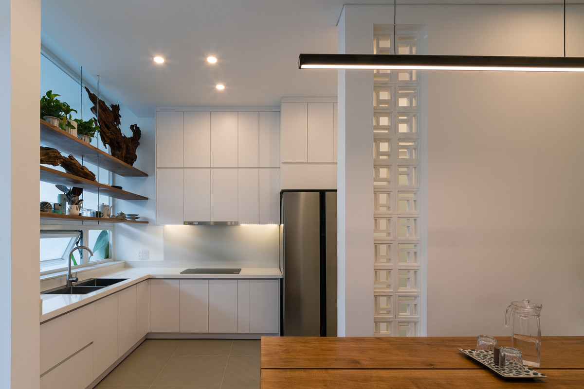 Nhà bếp thiết kế hiện đại với hệ thống tủ kệ màu trắng đơn giản. Ảnh: Quang Dam