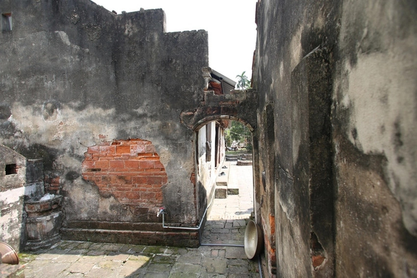 Nhiều mảng tường đã bong tróc, bức tường quét vôi đã trộn lẫn với màu rêu. Ảnh: Người đưa tin