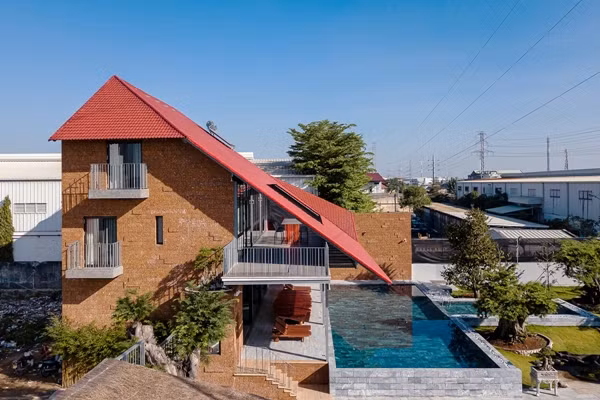 Tọa lạc tại quận Bình Tân (TP HCM), Roof Folding House nổi bật với mái gấp màu đỏ và toàn bộ mặt ngoài được ốp đá ong độc đáo. Ảnh: Quang Tran