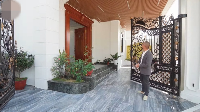 Cổng vào bề thế với những thanh sắt đặc và gia công hoàn toàn bằng thủ công. Các thanh sắt được uốn dựa theo thiết kế của cửa và có lớp sơn giả đồng. Ảnh chụp màn hình