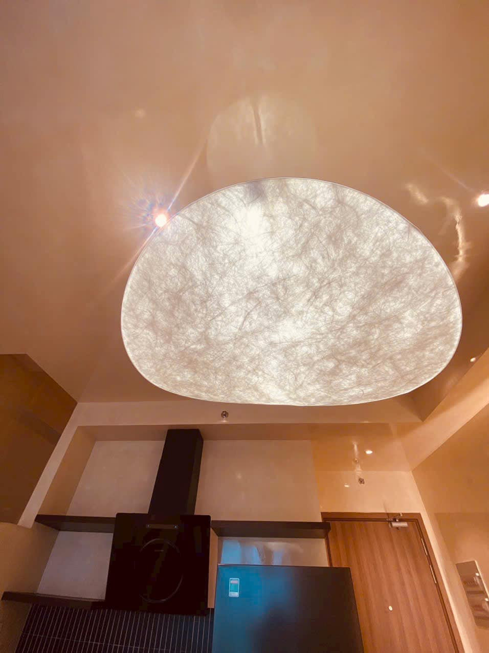 Phòng khách có tông màu trắng sáng chủ đạo, gương cách điệu và hệ thống đèn trần lạ mắt. Ảnh: FB Cao Thái Hà