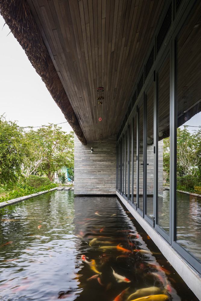 Lớp mái tôn ở “phần lõi” đảm bảo an toàn cho không gian bên trong, bên dưới lớp mái tôn là hệ trần gỗ hoàn thiện. Hệ mái 3 lớp là giải pháp làm giảm phần lớn nhiệt độ trong nhà so với bên ngoài, hạn chế bức xạ nhiệt tối đa trong những ngày nắng gắt. Ảnh: Hiroyuki Oki