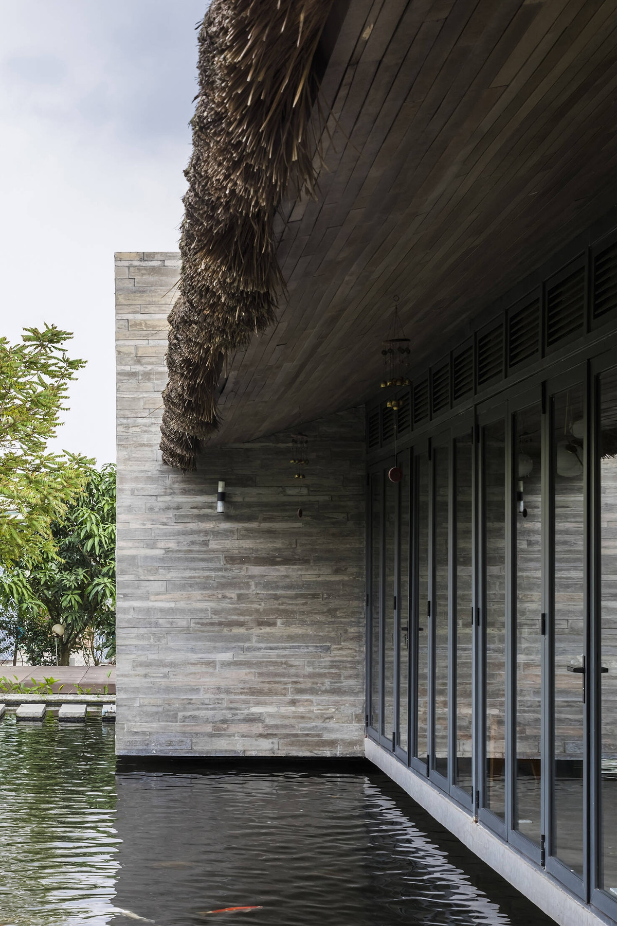 Trong đó, hệ mái tôn nằm chính giữa, bên trên là hệ mái tranh. Mái tranh là hình thức mái đặc trưng của kiến trúc khu vực miền Tây Nam Bộ, tạo cảm giác thân thuộc, gần gũi và giúp công trình hài hòa với thiên nhiên xung quanh. Ảnh: Hiroyuki Oki