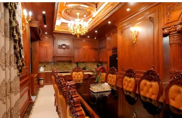 Bàn ăn dài ấm cúng, đủ cho 10 thành viên, phía trên có bộ đèn chùm dát vàng. Ảnh chụp màn hình NhaF