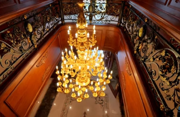 Phía trên khoảng thông tầng là chiếc đèn chùm dát vàng. Ảnh chụp màn hình NhaF