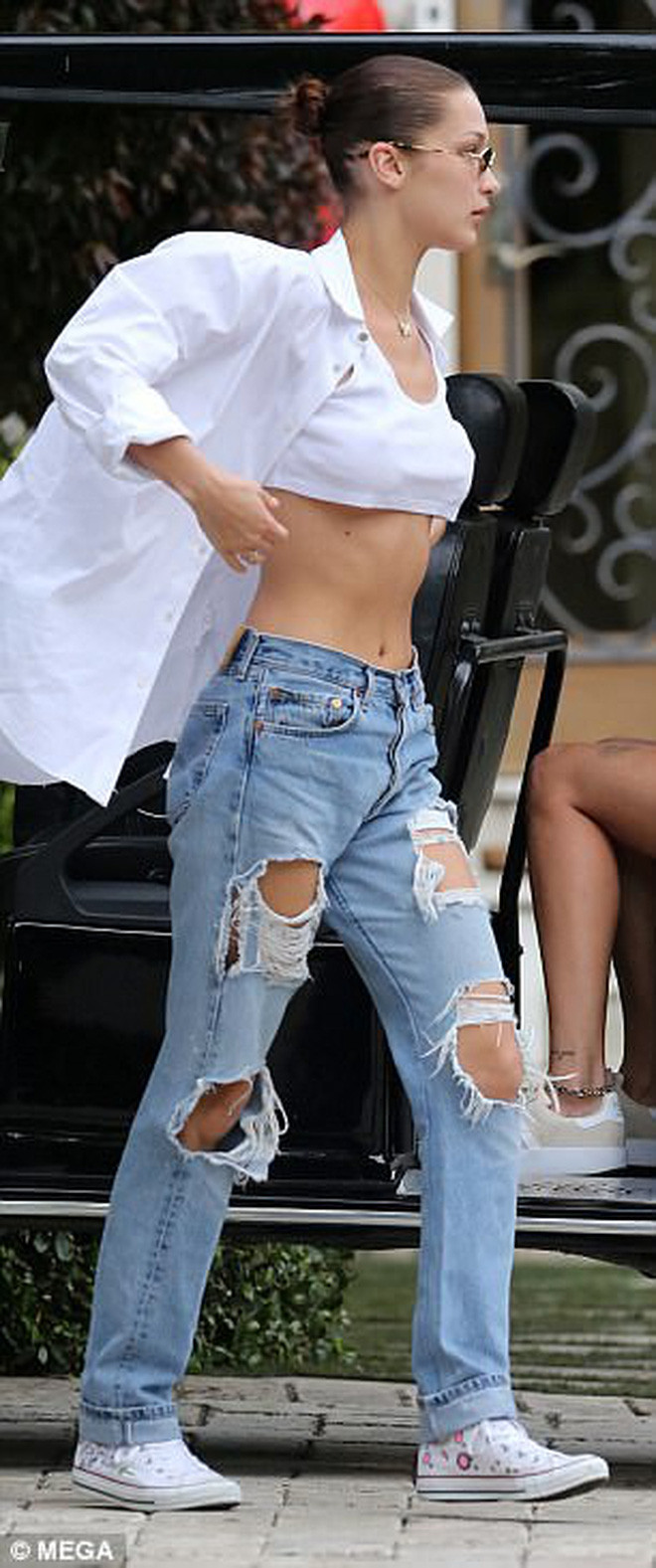 Bella Hadid trẻ trung, năng động hơn khi diện sơ mi trắng thay áo khoác kết hợp cùng quần jeans. Ảnh: Mega.