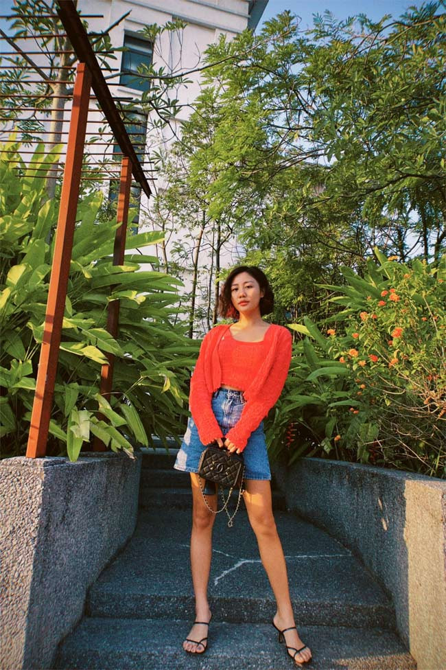 Chân váy jeans chữ A, áo len mỏng màu cam mang lại cho Văn Mai Hương một tổng thể thật năng động, trẻ trung.